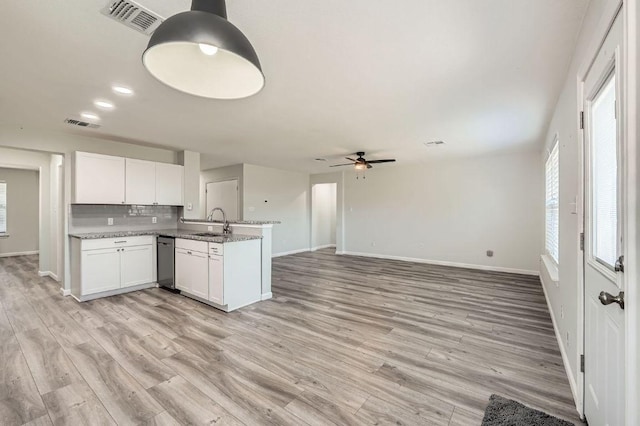 305 Bird Dog Bnd, Bastrop, TX 78602 - kitchen with a sink, a peninsula, baseboards, white cabinetry, and decorative backsplash