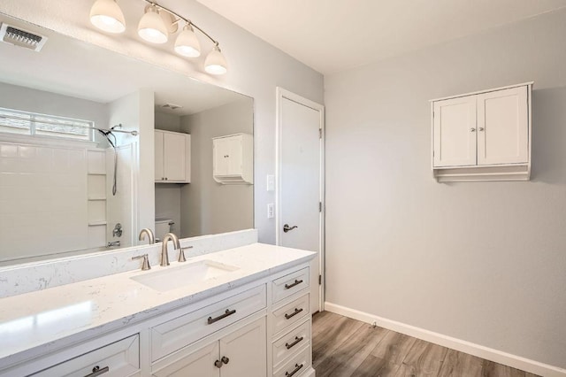305 Bird Dog Bnd, Bastrop, TX 78602 - bathroom with vanity, wood finished floors, baseboards, bathing tub / shower combination, and toilet