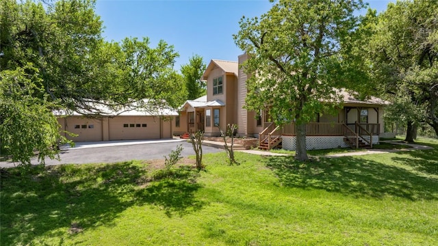view of front of home with a front lawn, aphalt driveway, covered porch, and a garage
