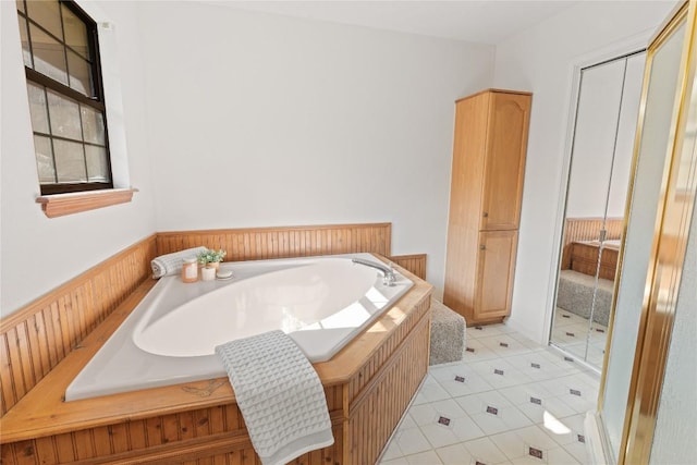 full bath featuring tile patterned floors and a garden tub