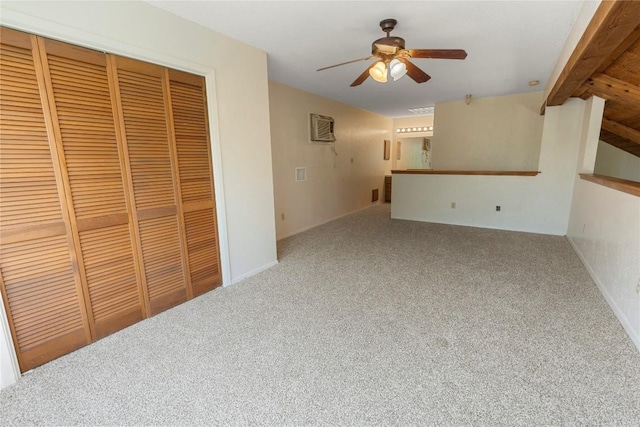 unfurnished living room featuring ceiling fan, carpet floors, and beam ceiling