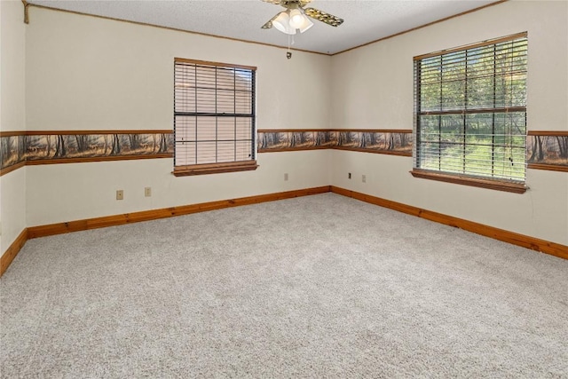 empty room with carpet, baseboards, and a ceiling fan