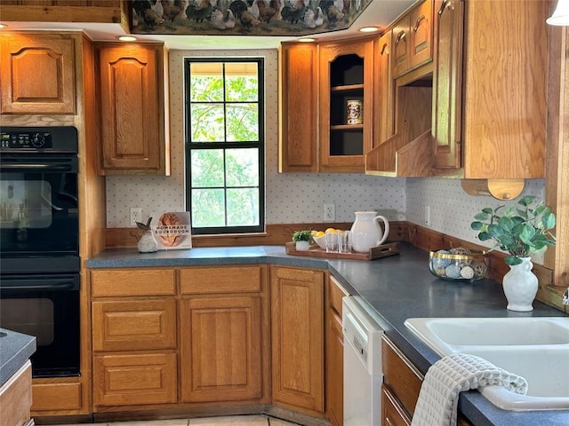 10400 Bitting School Rd, Manor, TX 78653 - kitchen with white dishwasher, brown cabinetry, dark countertops, and wallpapered walls