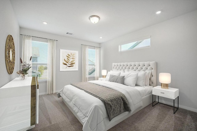 bedroom featuring baseboards, multiple windows, visible vents, and carpet