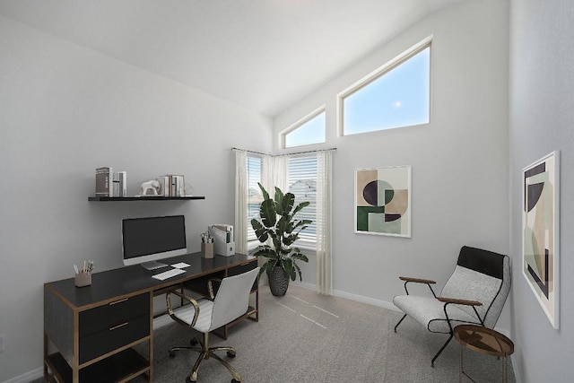 carpeted office space featuring a towering ceiling and baseboards