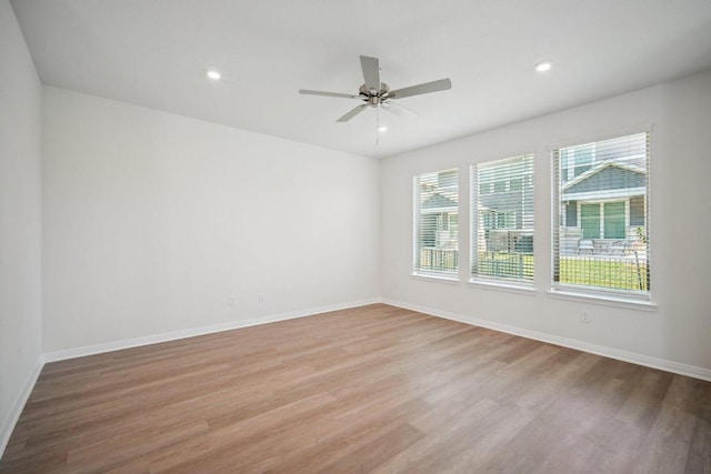 empty room with light wood finished floors, baseboards, a ceiling fan, and recessed lighting
