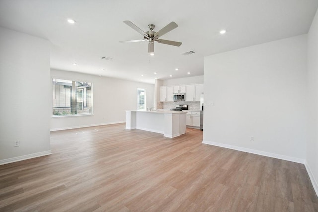 unfurnished living room featuring light wood finished floors, a ceiling fan, visible vents, baseboards, and recessed lighting