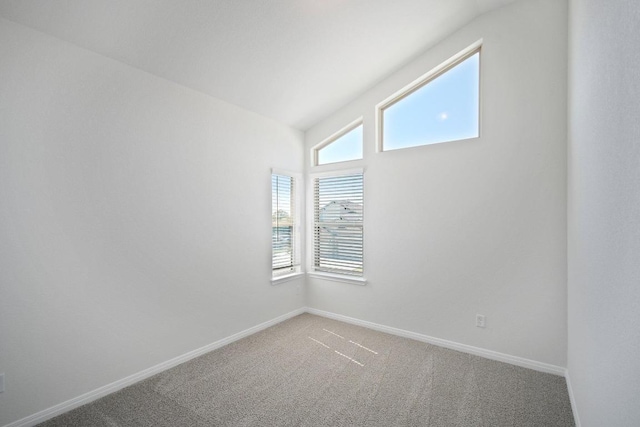 carpeted spare room featuring baseboards