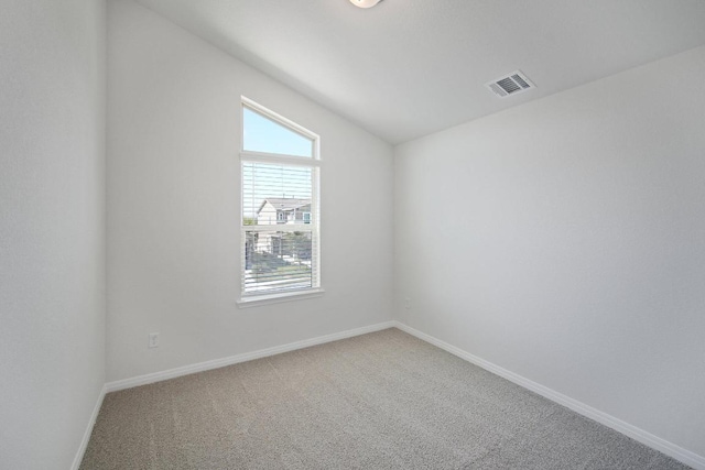 unfurnished room featuring vaulted ceiling, carpet flooring, baseboards, and visible vents