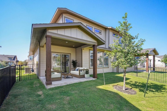 rear view of house featuring board and batten siding, a lawn, and a fenced backyard