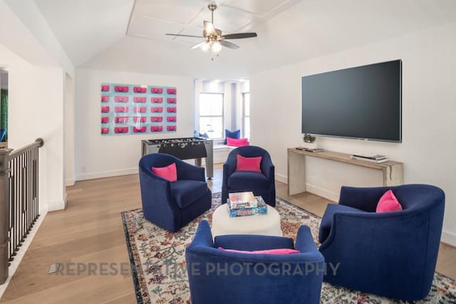 living area with baseboards, lofted ceiling, ceiling fan, and wood finished floors