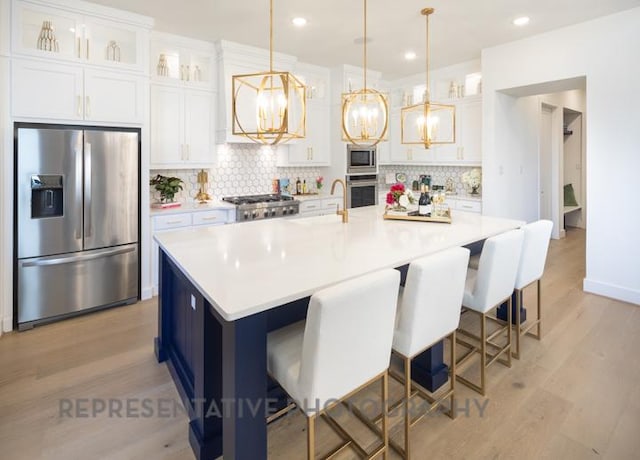kitchen featuring a chandelier, stainless steel appliances, backsplash, and white cabinets
