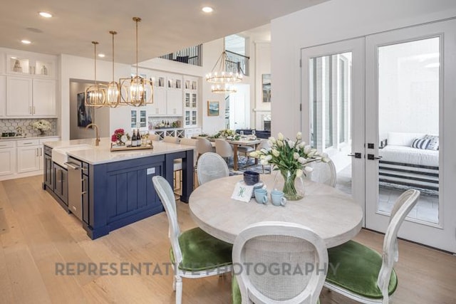 dining area with a chandelier, french doors, light wood-style flooring, and recessed lighting