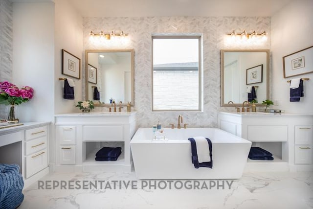 full bath with a soaking tub, marble finish floor, and vanity