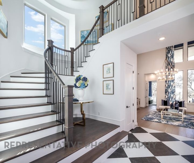 interior space with recessed lighting, baseboards, a towering ceiling, and a notable chandelier