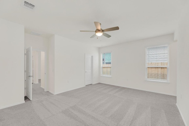 carpeted empty room featuring a ceiling fan, baseboards, and visible vents