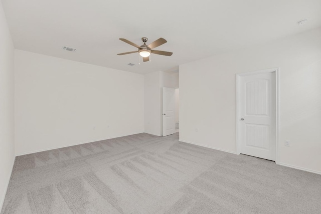 carpeted spare room featuring visible vents, baseboards, and a ceiling fan