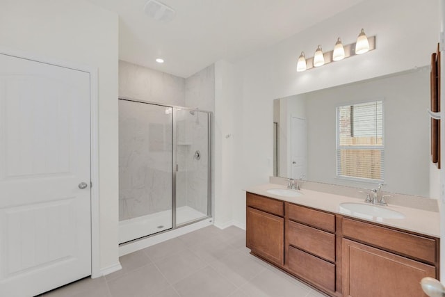 full bathroom featuring double vanity, tile patterned flooring, a stall shower, and a sink