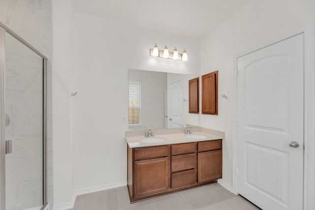 bathroom featuring tile patterned floors, a stall shower, and a sink
