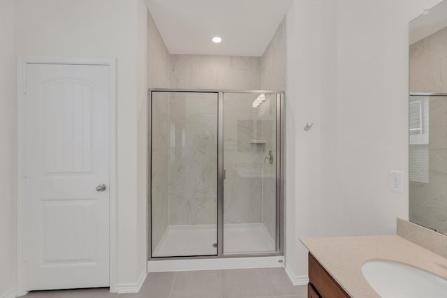 full bathroom featuring a shower stall, baseboards, tile patterned floors, and vanity