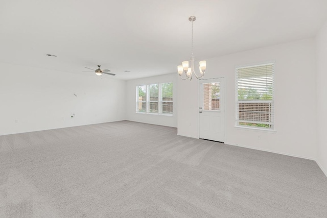 empty room featuring light carpet and ceiling fan with notable chandelier