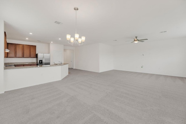 unfurnished living room with light carpet, visible vents, recessed lighting, and ceiling fan with notable chandelier