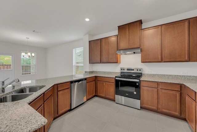 kitchen featuring under cabinet range hood, stainless steel appliances, a wealth of natural light, and a sink