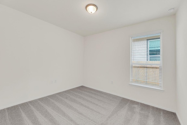 carpeted spare room with baseboards