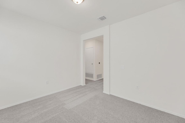 spare room featuring carpet flooring, visible vents, and baseboards