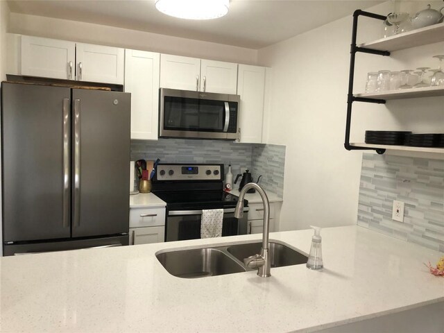 6409 Burns St Unit 306, Austin, TX 78752 - kitchen with white cabinetry, backsplash, appliances with stainless steel finishes, and a sink