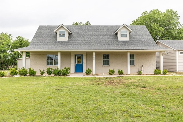 view of front of home with roof with shingles, a front lawn, and brick siding