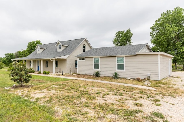 view of front of house with a shingled roof and a front yard