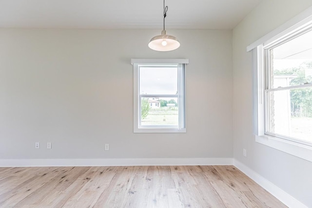 empty room featuring light wood finished floors and baseboards
