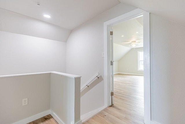 hall with lofted ceiling, recessed lighting, baseboards, wood finished floors, and an upstairs landing