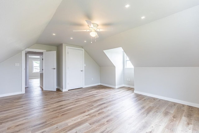 bonus room with light wood finished floors, vaulted ceiling, baseboards, and a ceiling fan