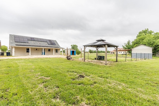 view of yard featuring a gazebo, a storage shed, and an outbuilding