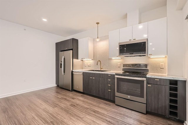 4361 S Congress Ave Unit 236, Austin, TX 78745 - kitchen featuring stainless steel appliances, a sink, light countertops, tasteful backsplash, and light wood finished floors