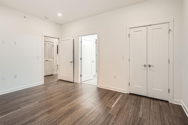 4361 S Congress Ave Unit 236, Austin, TX 78745 - unfurnished bedroom featuring dark wood-style floors, baseboards, and a closet