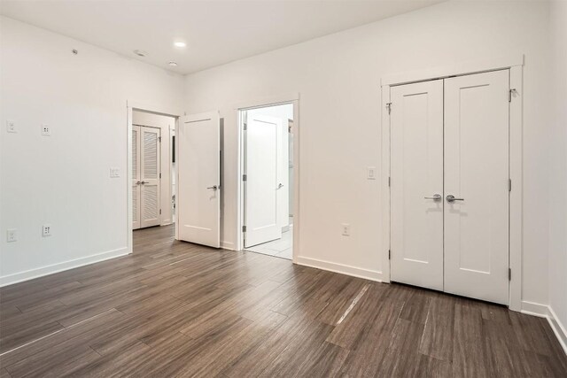 4361 S Congress Ave Unit 236, Austin, TX 78745 - unfurnished bedroom with dark wood-style floors, baseboards, and a closet