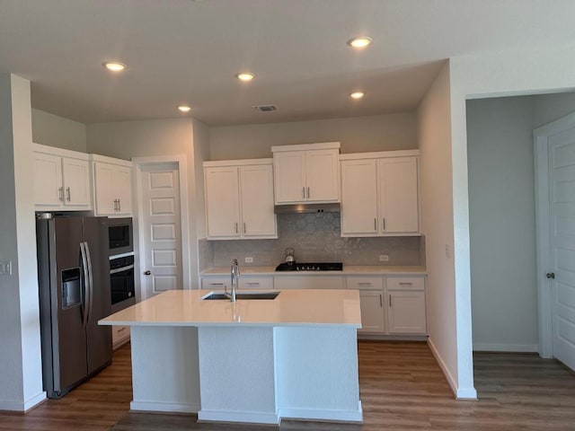 4319 Port Hope St, Round Rock, TX 78665 - kitchen with appliances with stainless steel finishes, dark wood finished floors, under cabinet range hood, backsplash, and recessed lighting