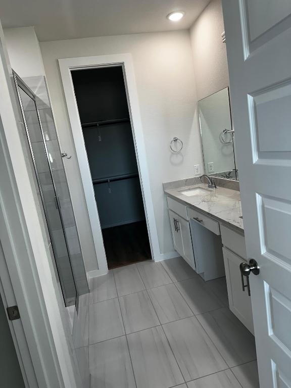 4319 Port Hope St, Round Rock, TX 78665 - full bath featuring vanity, a stall shower, a walk in closet, and tile patterned flooring