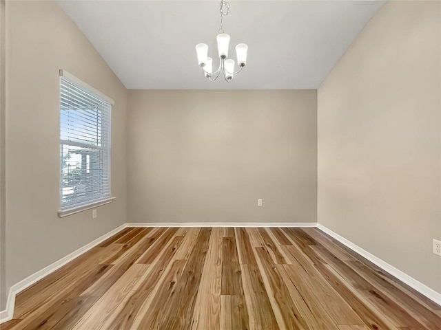 127 Navidad River Dr, Hutto, TX 78634 - spare room with a chandelier, light wood-style floors, and baseboards