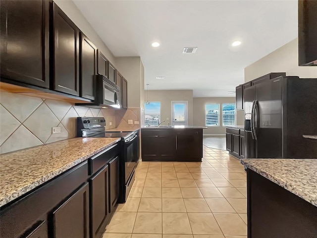 127 Navidad River Dr, Hutto, TX 78634 - kitchen with black appliances, backsplash, a peninsula, light tile patterned floors, and a sink