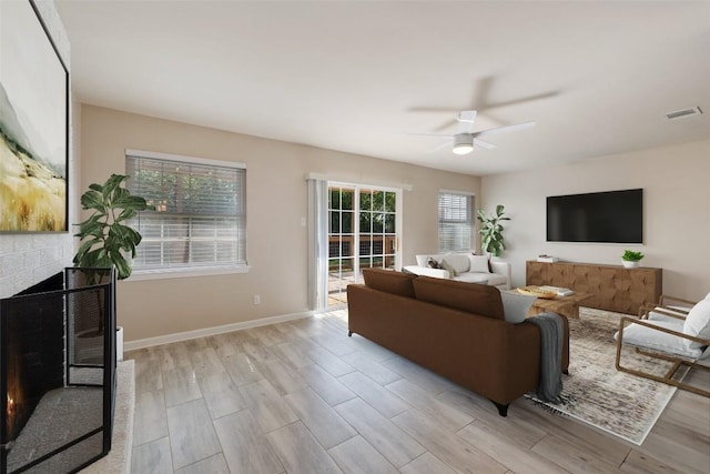 216 Lizzie St, Taylor, TX 76574 - living room featuring ceiling fan, light wood-style flooring, and a fireplace
