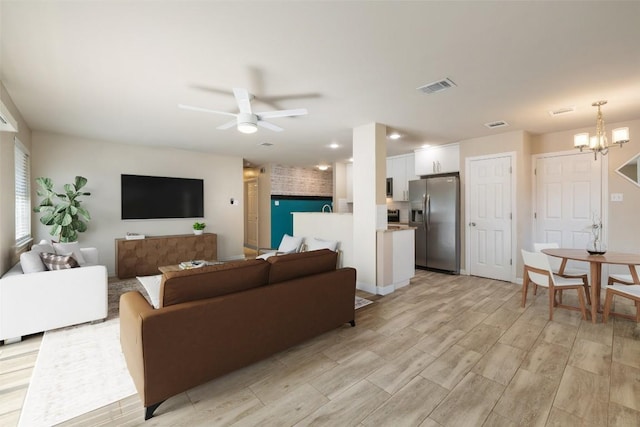 216 Lizzie St, Taylor, TX 76574 - living area with ceiling fan, light wood-type flooring, and a chandelier