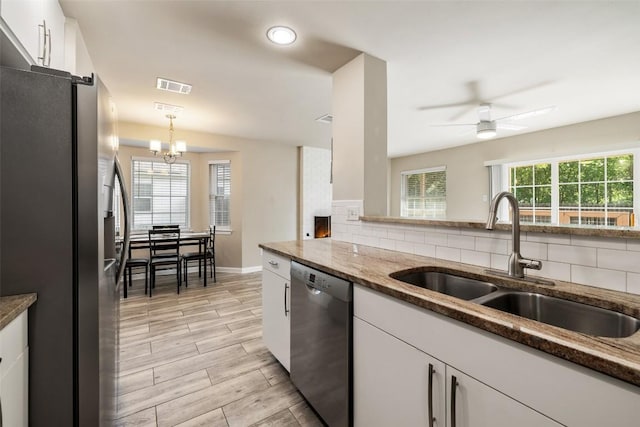 216 Lizzie St, Taylor, TX 76574 - kitchen with appliances with stainless steel finishes, decorative backsplash, white cabinets, a ceiling fan, and recessed lighting