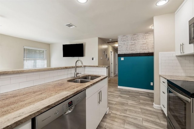 216 Lizzie St, Taylor, TX 76574 - kitchen featuring stainless steel appliances, decorative backsplash, white cabinets, and recessed lighting