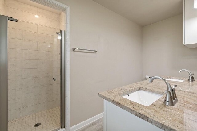 216 Lizzie St, Taylor, TX 76574 - bathroom with a stall shower, vanity, and wood finished floors