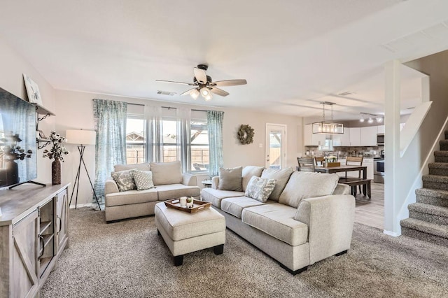 338 Liberty St, Hutto, TX 78634 - living area with stairway, ceiling fan, light colored carpet, and visible vents