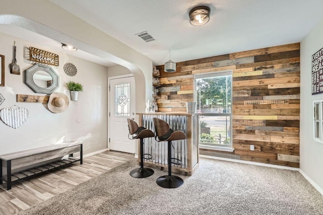 338 Liberty St, Hutto, TX 78634 - bar featuring wooden walls, arched walkways, baseboards, and visible vents